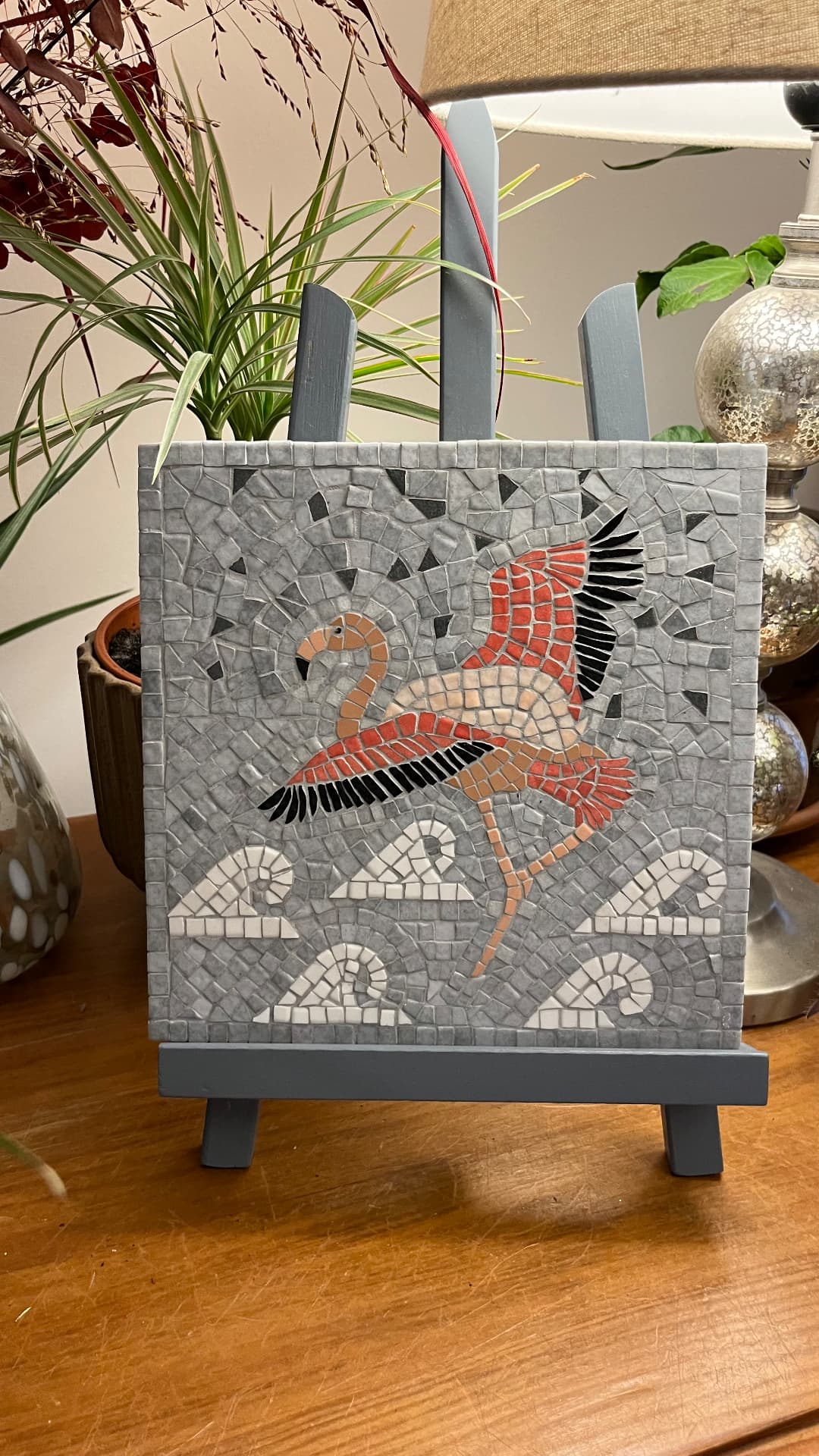 Tableau en mosaïque de marbre représentant un flamant rose au-dessus de vagues stylisées